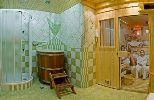 a room with a tub and people sitting in a bathroom at Hotel Toporów in Białka Tatrzanska