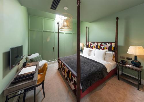 a bedroom with a bed and a desk with a desk at The City of London Club in London