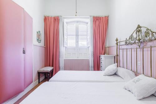 a bedroom with two beds and a window with red curtains at Cortijo EL LLANO in Almería