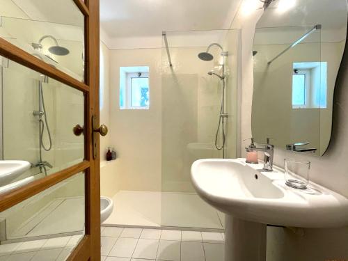 a white bathroom with a sink and a shower at Sea House in Viana do Castelo