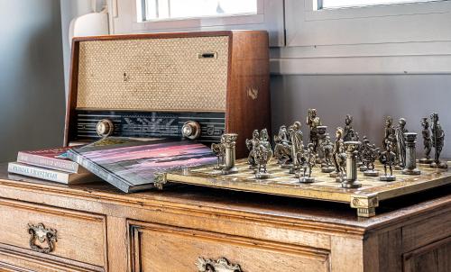 a chess board on a dresser with a mirror and books at Apostolos Loft - Cozy Loft in the Center of Preveza in Preveza