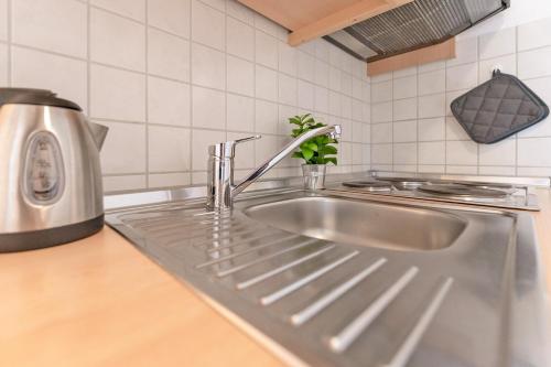 eine Küchenspüle mit einem Wasserhahn darüber in der Unterkunft Fahrenkrug Wohnung 4 in Scharbeutz