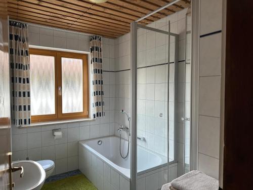 uma casa de banho com uma banheira, um chuveiro e um lavatório. em Maier Chalet em Bayerisch Eisenstein