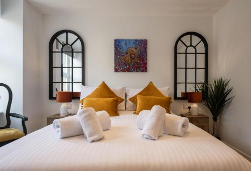 a bedroom with a large white bed with yellow pillows at Mrs Watermelon Apartment in Fort William