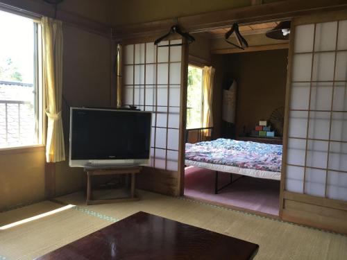 sala de estar con TV y cama en Guesthouse In Lak'ech - Vacation STAY 03558v, en Kami-ikusaka