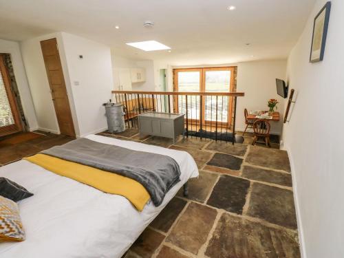 ein Schlafzimmer mit einem großen Bett und einem Balkon in der Unterkunft The Barn at Crow Hill Shaw Farm in Sowerby Bridge