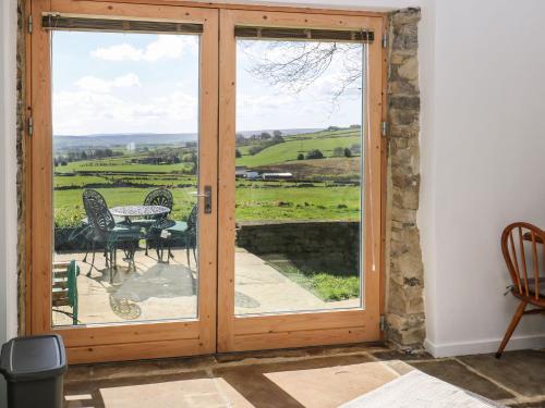 a sliding glass door with a view of the countryside at The Barn at Crow Hill Shaw Farm in Sowerby Bridge