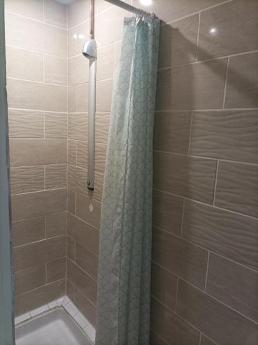 une salle de bain avec une douche avec un rideau de douche dans l'établissement Tente 3 chambres, petit camping familial près des plages, à Plestin-les-Grèves