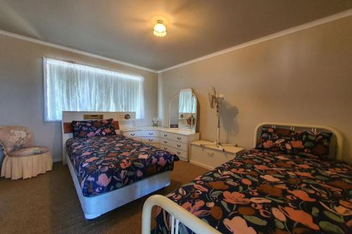 吉爾德頓的住宿－Dhu View - Views for days，一间卧室设有两张床、镜子和窗户