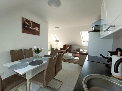 cocina y sala de estar con mesa y sillas en Flower Apartman 6, 
