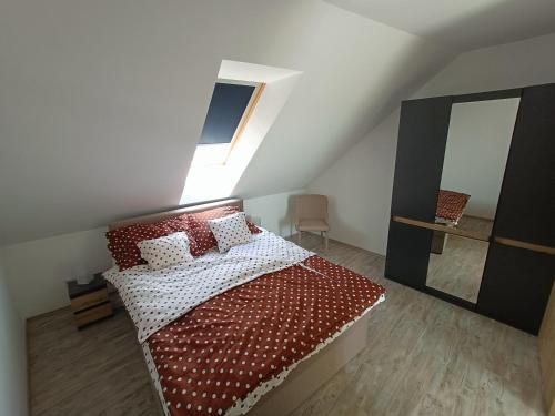 een slaapkamer met een bed met rode en witte kussens bij Flower Apartman 6 