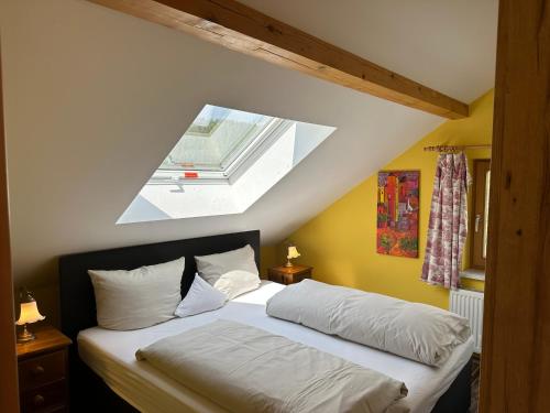 um quarto com uma cama e uma clarabóia em Maier Chalet em Bayerisch Eisenstein