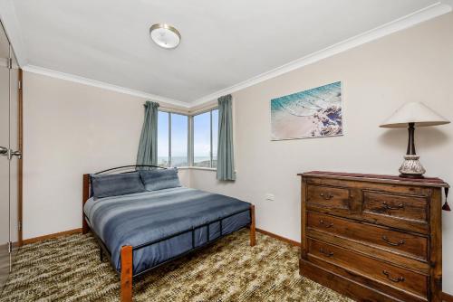 a bedroom with a bed and a dresser and a window at Coastal Pine in Guilderton