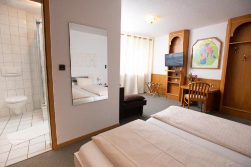 a hotel room with a bed and a bathroom at Landhotel zum Stern in Waldkappel