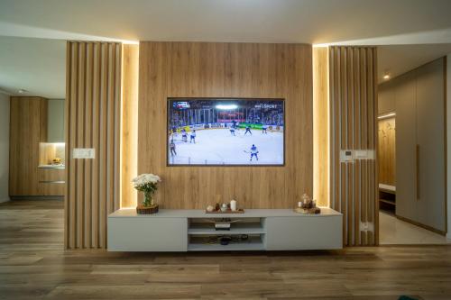 a living room with a tv on a wall at Po City Newly Built Apartment in Prešov