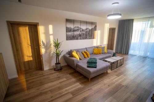 a living room with a couch and wooden floors at Po City Newly Built Apartment in Prešov
