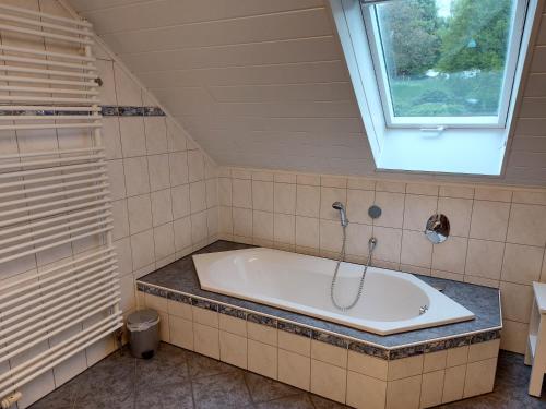 a bath tub in a bathroom with a window at Ferienwohnung Frühlingstraße in Mehlbach