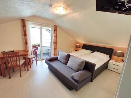 a bedroom with a bed and a couch and a table at Haus am See in Sankt Kanzian