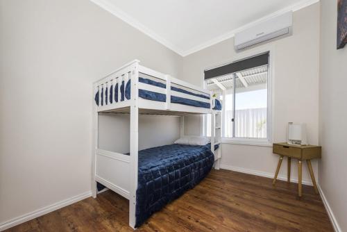 ein Schlafzimmer mit einem Etagenbett und einem Fenster in der Unterkunft Park View - Great family holiday house Pet Friendly in Lancelin
