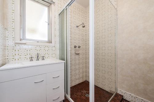 a bathroom with a white sink and a shower at Relax Moore - Close to Beach in Guilderton