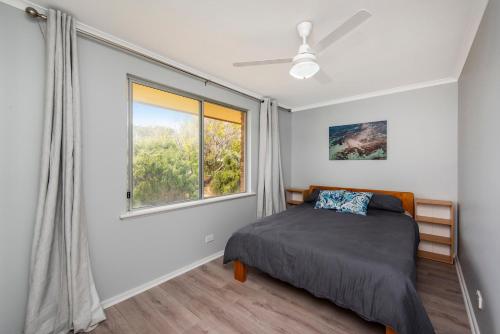 Schlafzimmer mit einem Bett und einem Fenster in der Unterkunft Sunset View- Ocean Views in Lancelin