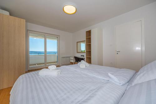 sypialnia z białym łóżkiem i ręcznikami w obiekcie Villa Veronika Apartments w Crikvenicy