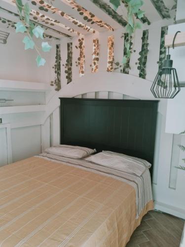 a bedroom with a bed with a green headboard at B&B Angelica Apartment in Benevento
