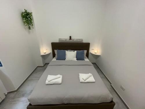 um quarto com uma grande cama branca e 2 almofadas em Tiny House - 15 minutes to Duomo em Milão