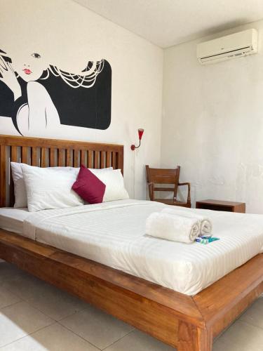 ein Schlafzimmer mit einem großen Bett mit Holzrahmen in der Unterkunft Rumahku Bali Executive in Kuta