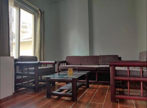 un soggiorno con divano e tavolo di Gracia Locus- Home Comfort a Dimāpur