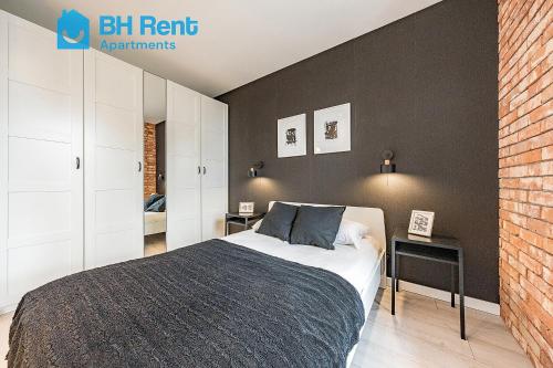 グダニスクにあるBH Rent Apartments, Gdańsk Krynicka 2, SoHoのレンガの壁、ベッド付きのベッドルーム1室