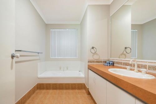 吉爾德頓的住宿－Waves And Moore - Beautifully presented home，浴室配有两个盥洗盆和浴缸。