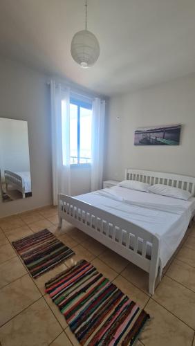 a bedroom with a white bed and a window at The Place in Vlorë