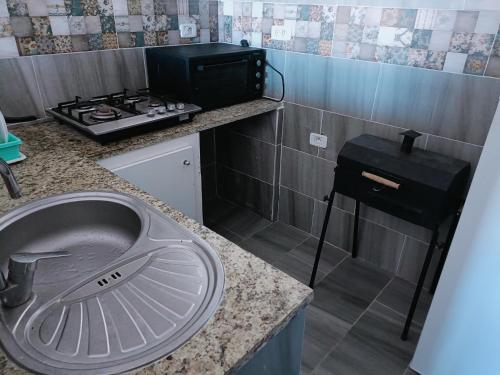 a kitchen with a sink and a stove at Family corner in Ḩammām al Ghazzāz