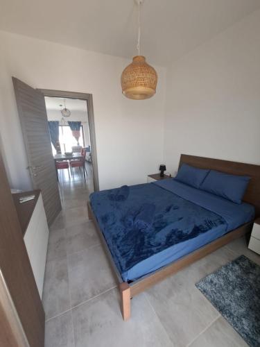 a bedroom with a bed with blue sheets and a mirror at the Queen Freddy Penthouse in Taʼ Xbiex