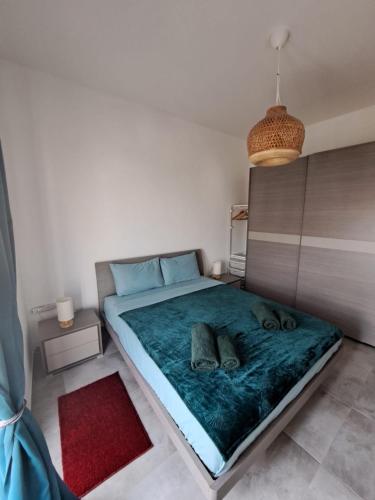 a bedroom with a large bed with a green blanket at the Queen Freddy Penthouse in Taʼ Xbiex