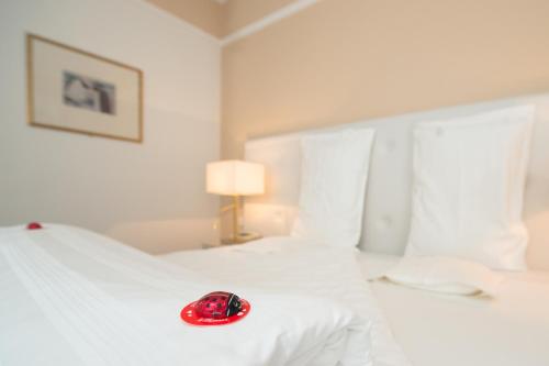 a red hat on a white bed in a room at Seegarten in Caldaro
