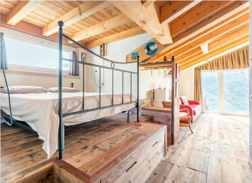 ein Schlafzimmer mit einem Bett in einem Zimmer mit Holzdecken in der Unterkunft Foresteria B&B Vecchiascuola Pianazzola in Chiavenna