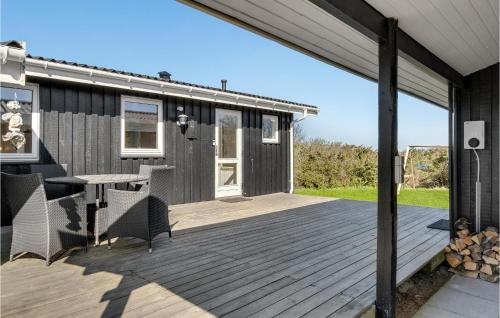 a deck with a table and chairs on a house at Holiday Home Øster Kjulvej in Hirtshals