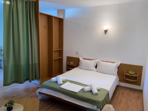 - une chambre avec un lit blanc et un rideau vert dans l'établissement Хотел ЗОНАРИТА, à Primorsko