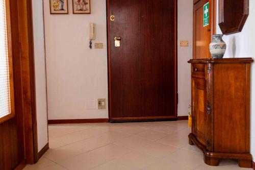 a hallway with a wooden door and a cabinet at L'anfiteatro in Vercelli