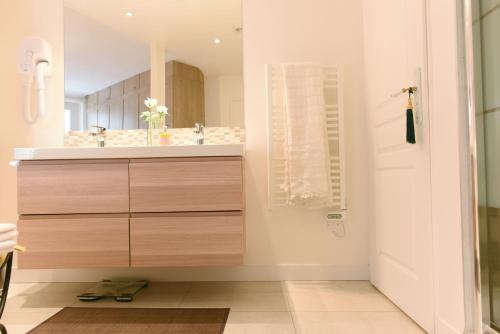 une salle de bain avec un lavabo et un miroir dans l'établissement Sophisticated Gem in the Heart of Paris - 107m2, à Paris