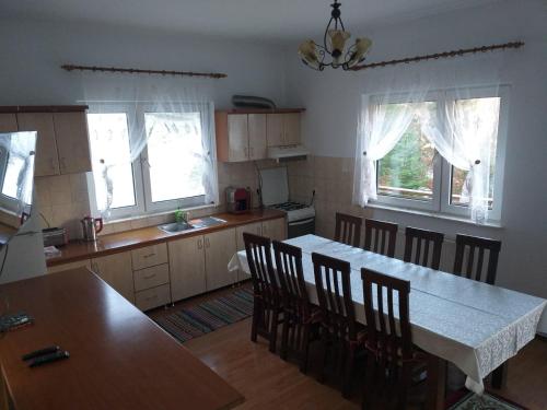 a kitchen with a table and chairs in a room at Șoaptele pădurii & Căsuța din pădure in Suceviţa