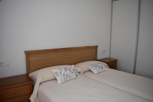 a bedroom with a bed with two pillows on it at Vivienda de Uso Turístico ABELLA in Matarrosa del Sil