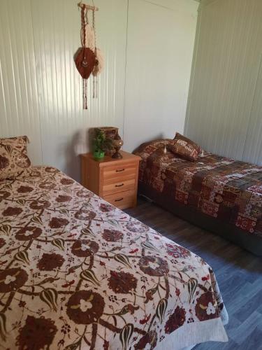 sypialnia z 2 łóżkami i drewnianą komodą w obiekcie Field Of Possibilites - Kayakoy Retreat w mieście Kayakoy
