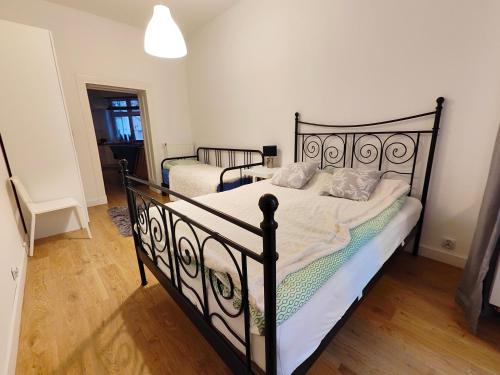 a bedroom with two black beds with white sheets at Apartament Wybickiego in Poznań