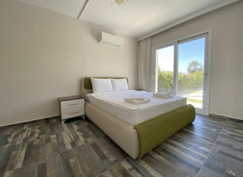 1 dormitorio con cama grande y ventana grande en PETRUM SUNSET RESİDENCE HOTEL, en Bodrum City
