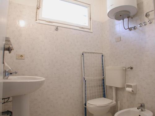 リド・デッリ・エステンシにあるVilletta Caminiのバスルーム(トイレ、洗面台付)、窓が備わります。