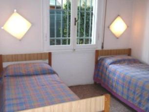 a bedroom with two beds and a window at Villetta Camini in Lido degli Estensi