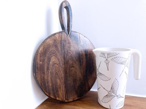 a wooden bowl and a mug on a table at Résidence du Platane in Saint-Laurent-des-Arbres